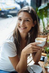 Glückliche Frau sitzt mit Kaffee in einem Cafe - JOSEF17566