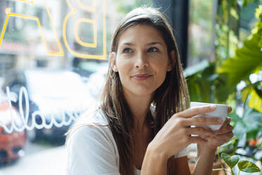 Nachdenkliche Frau mit Kaffeetasse in einem Cafe - JOSEF17608