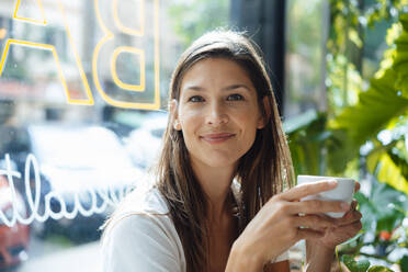 Smiling woman with coffee cup in cafe - JOSEF17609