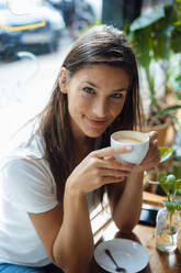 Smiling woman having coffee in cafe - JOSEF17610