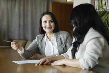 Businesswoman discussing with colleague in meeting at office - NJAF00293