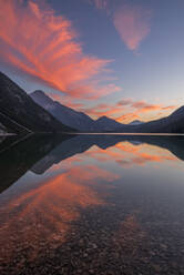 Austria, Tyrol, Clouds reflecting in Heiterwanger See at dusk - RUEF03990