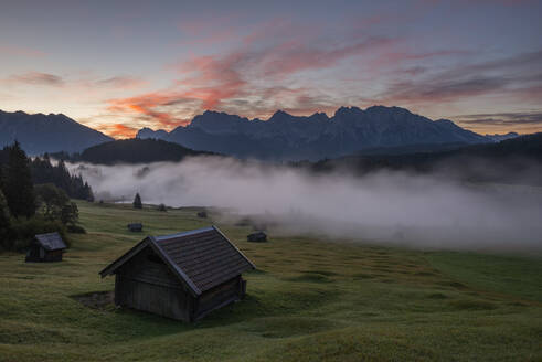 Deutschland, Bayern, Dichter Morgennebel über dem Geroldsee mit Hütte im Vordergrund - RUEF03995