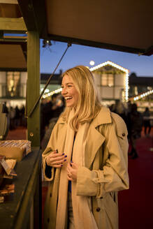 Happy woman standing outside concession stand - JJF00680