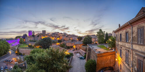 Italien, Latium, Tuscania, Panoramablick auf eine mittelalterliche Stadt in der Abenddämmerung - MAMF02658