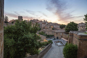 Italien, Latium, Tuscania, Blick auf eine mittelalterliche Stadt in der Abenddämmerung - MAMF02668