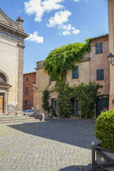 Italien, Latium, Tuscania, Außenansicht eines überwucherten Stadthauses im Sommer - MAMF02675