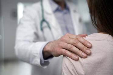 Doctor consoling patient at clinic - ABIF01850