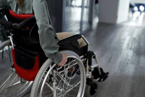 Woman with disability sitting in wheelchair at clinic - ABIF01867