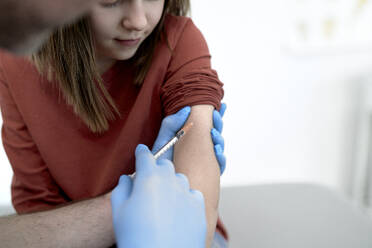 Hände eines Arztes bei der Impfung eines Patienten in einer Klinik - ABIF01888