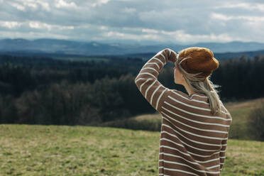 Woman wearing knit hat looking at mountains - VSNF00623