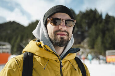 Lächelnder Mann mit Sonnenbrille im Skigebiet - ALKF00185
