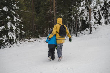 Vater geht mit Arm um Sohn im Schnee - ALKF00191