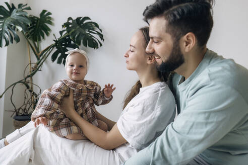 Glücklicher Vater und glückliche Mutter genießen mit ihrer Tochter - AAZF00157