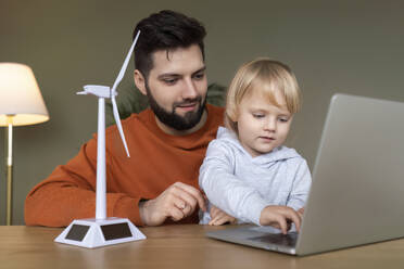 Father with son studying on laptop at home - AAZF00163