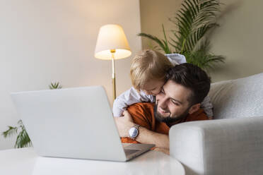 Glücklicher Vater und Sohn genießen im Wohnzimmer zu Hause - AAZF00165