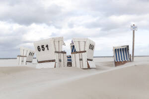 Deutschland, Schleswig-Holstein, St. Peter-Ording, Strandkörbe mit Kapuze am Sandstrand - ASCF01740