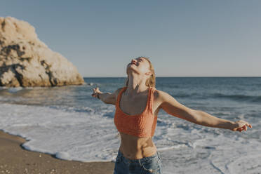 Sorglose Frau am Strand an einem sonnigen Tag - DMGF01096