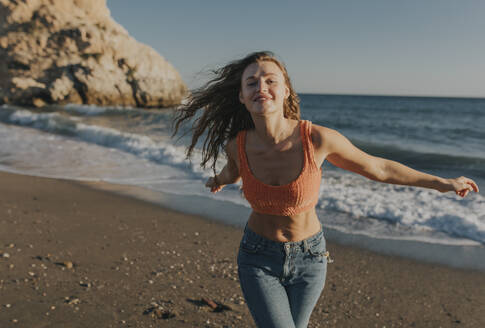 Cheerful woman enjoying at beach - DMGF01099