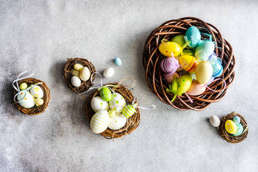 Draufsicht Ostern Urlaub Karte mit Kränzen voll von multicolor Eier auf konkreten Hintergrund - ADSF43444