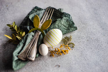 From above place setting for Easter dinner in green color on concrete background - ADSF43446