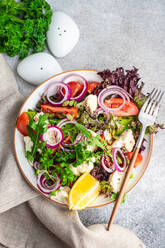 Organic vegetable salad with seasonal vegetables and herb mix with seeds and lemon in a bowl - ADSF43449