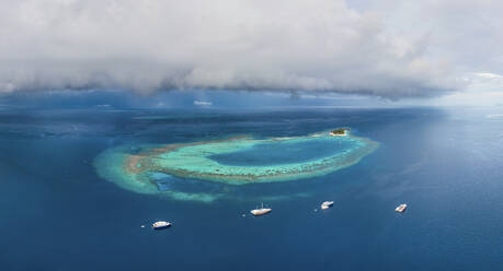 Panoramablick aus der Vogelperspektive auf Luxusyachten, die entlang des Atolls auf den Malediven angedockt sind. - AAEF17533