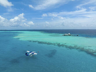 Luftaufnahme eines Flugzeugs, das im Indischen Ozean in der Nähe der Insel Huluwalu, Malediven, landet. - AAEF17541