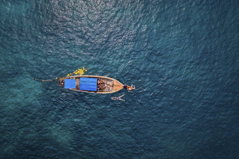Luftaufnahme von Menschen, die sich auf einem traditionellen Fischerboot auf der Insel Phi Phi, Krabi, Thailand, vergnügen. - AAEF17561