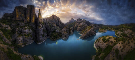 Panoramablick auf den Rio Guatizalema in der Nähe des Presa de Vadiello-Stausees mit einer Bergkette im Hintergrund bei Sonnenuntergang, Loporzano, Huesca, Spanien. - AAEF17597