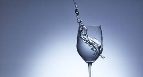 Studioaufnahme von klarem Wasser, das in ein Weinglas fließt - KSWF02332