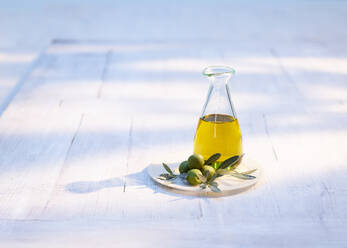 Carafe of olive oil on wooden coaster - KSWF02339