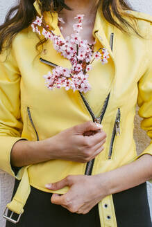 Frau mit Kirschblütenblüten in gelber Jacke - EGHF00737