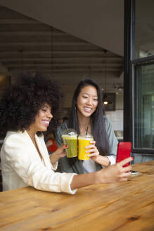 Freunde halten einen Moment der Gesundheit und des Glücks mit einem Selfie fest, während sie in einem Café nahrhafte Getränke genießen - MMPF00689