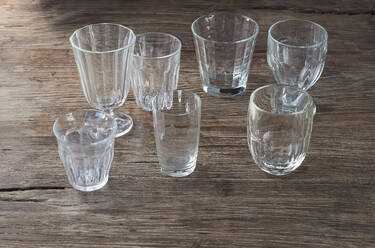 Sammlung von leeren Gläsern, die auf einer Holzfläche stehen - KSWF02349