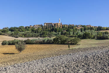 Italien, Toskana, Pienza, Ländliche Landschaft im Sommer mit Stadtrand im Hintergrund - FOF13624