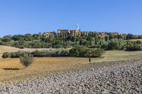Italien, Toskana, Pienza, Ländliche Landschaft im Sommer mit Stadtrand im Hintergrund - FOF13624