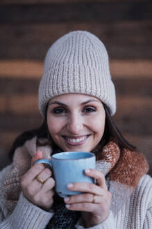 Glückliche Frau in warmer Kleidung beim Kaffee trinken - JOSEF17741