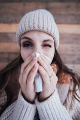 Sick young woman wiping nose with tissue - JOSEF17747