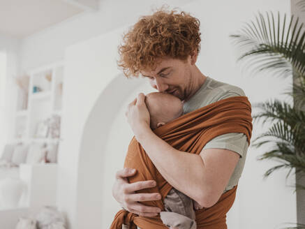 Father carrying and embracing son at home - MFF09280