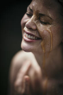 Happy woman with liquid on face at health spa - MJRF00926