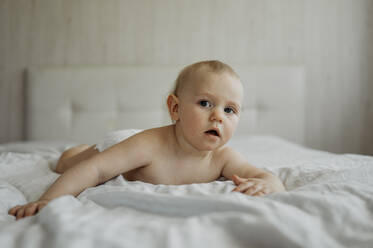 Shirtless boy lying on bed at home - ANAF01109