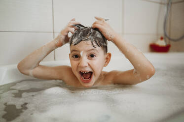 Glücklicher Junge hat Spaß in der Badewanne zu Hause - ANAF01121