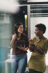 Businesswoman having discussion with colleague in office - JOSEF17801