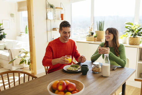 Ehepaar frühstückt am Esstisch sitzend in einem Haus - EBSF03014