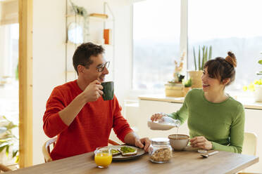 Happy couple having breakfast at home - EBSF03017