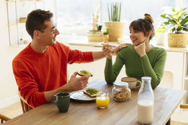 Happy woman and man eating breakfast at home - EBSF03018