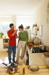 Man feeding woman by kitchen counter at home - EBSF03021