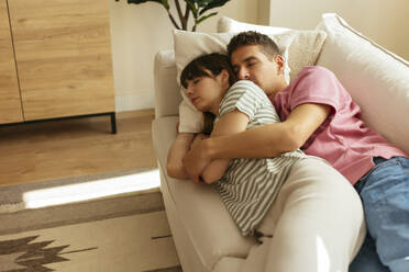 Affectionate couple sleeping on sofa at home together - EBSF03034