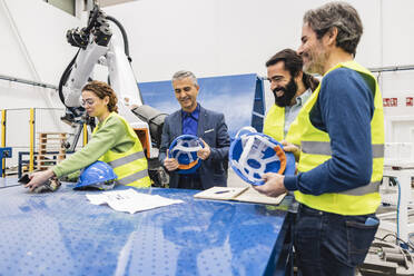 Ingenieure mit Schutzhelm bei einer Diskussion in der Industrie - JCCMF09956